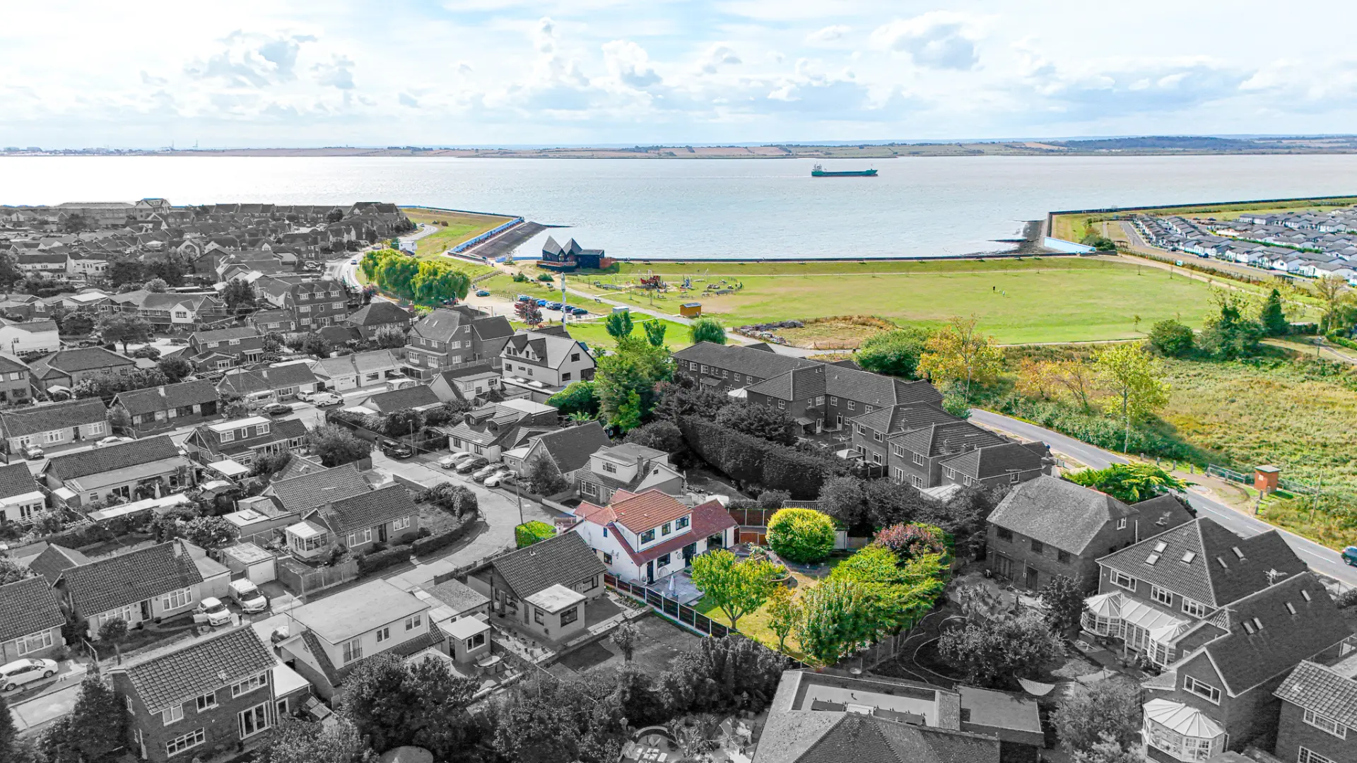 Aerial property photograph overlooking homes, green space and the river